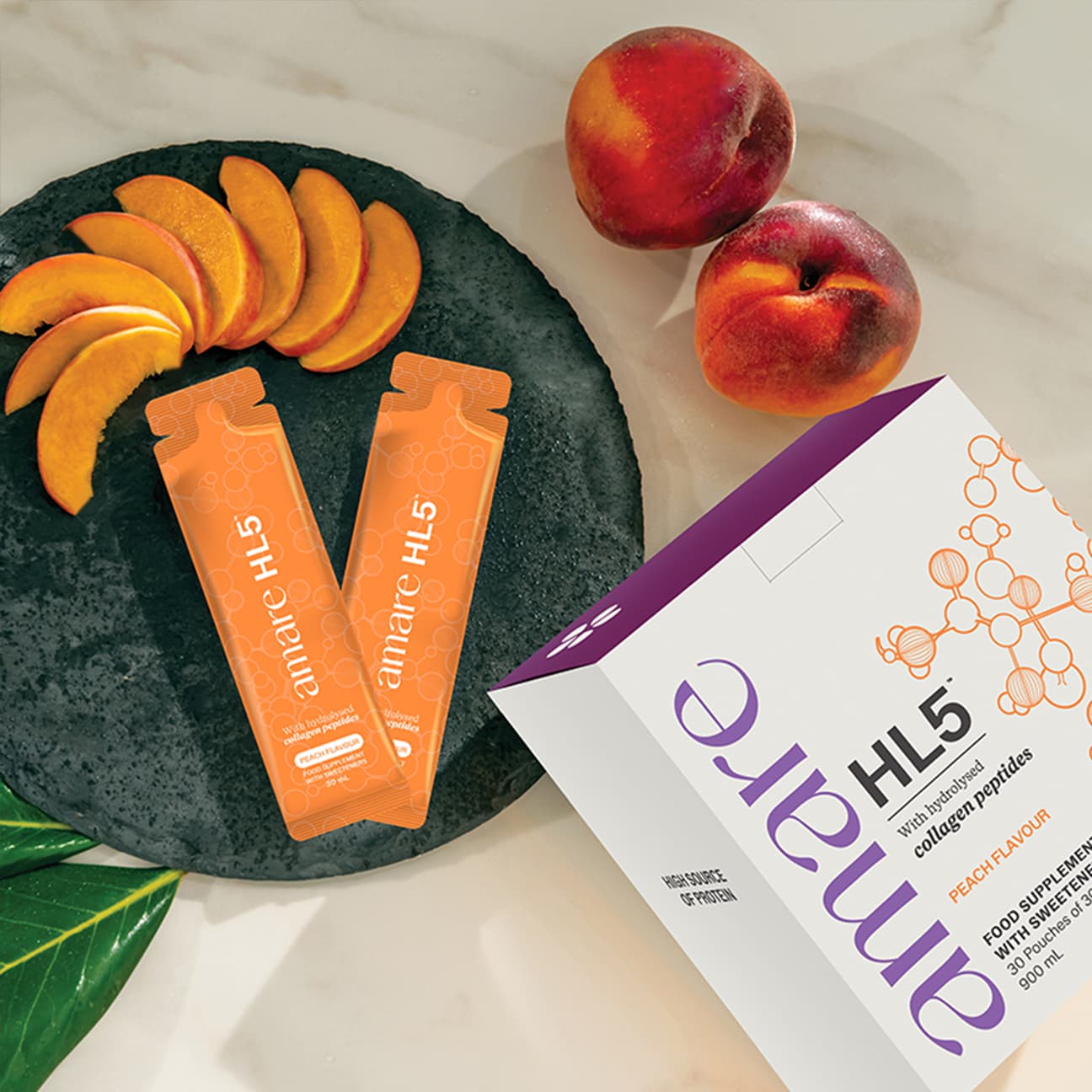 Amare HL5 vloeibaar collageen sachets met perzik smaak naast verse perziken — collageen supplement voor huid, haar en nagels